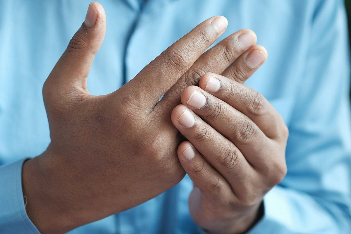 Hände, die sich gegenseitig an den schmerzenden Fingergelenken halten